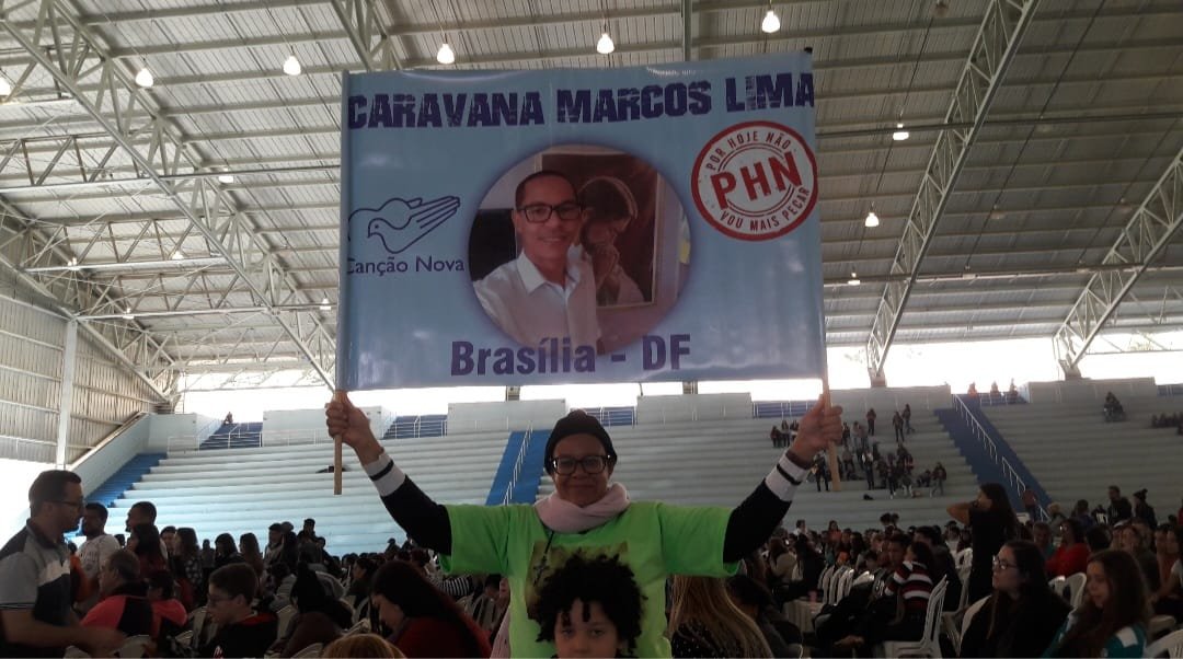Participante ergue a faixa oficial da Caravana Brasília - DF durante a programação do PHN