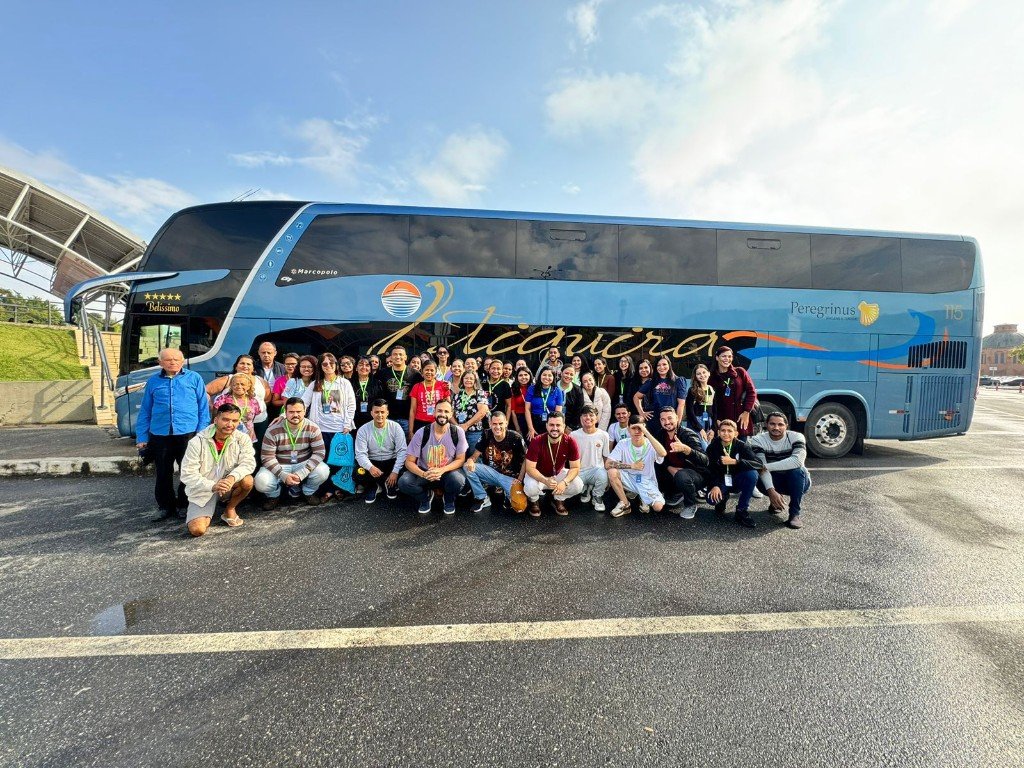 Grupo da caravana reunido diante do ônibus antes de seguir viagem