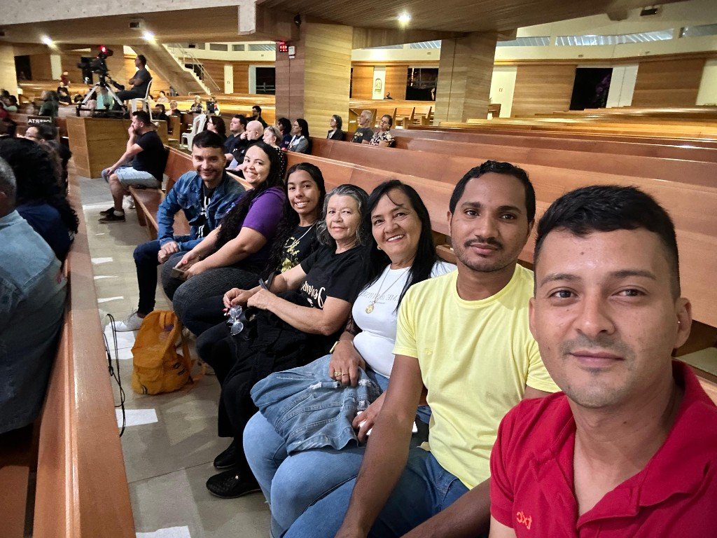 Participantes da caravana reunidos nos bancos durante uma celebração